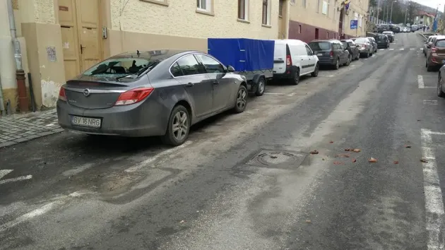 Luneta unei mașini, spartă de o țiglă căzută de pe o clădire de pe strada Castelului