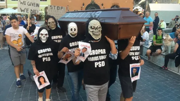 Deghizaţi în parlamentarii PSD şi ALDE de Braşov, protest cu ‘înmormântare‘ la Braşov. Şi cu cătuşe centenar